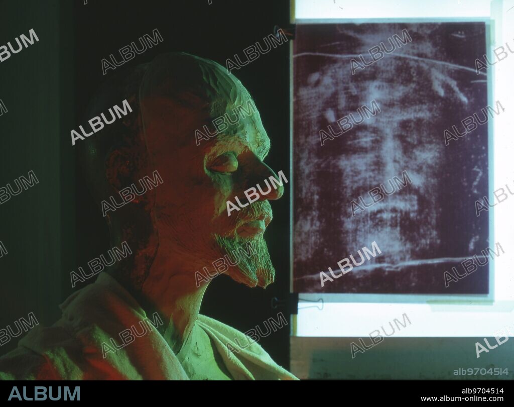 Turin Shroud. Photograph of a bust of the ' Man of the Shroud ' , sculpted from a minute survey of the face on the Turin Shroud . Three quarter view ( left side ) , against a frontal enlargement of the facial detail of the shroud , and negative & positive images of the shroud .