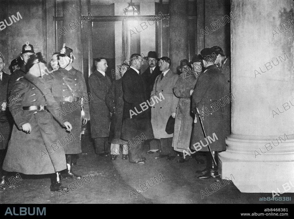 Orig. bildtext... DER REICHSTAG BRENNT. Erste Aufnahme, photographiert während des nächtlichen Riesenbrandes im Reichstags gebäude. U.B.z. Schon kurz nach der ersten Brandmeldung traf der Reichskanzler in dem Reichstagsgebäude ein. Links absperrende Polizeibeamte im Wandelgang im Reichstag. Rechts von diesen v.l.n.r. Hanke, der Sekretär Dr. Goebbels; Dr. Goebbels; Schaub, der persönliche Sekretär Hitlers; Prinz August-Wilhelm; Reichskanzler Hitler; Winkler, der persönliche Sicherheits beamte des Reichskanzlers; und Reichsminister und Reichstagspräsident Goering. Anm. CD235 persons: Joseph Goebbels ;Adolf Hitler ;Hermann Göring sites: TYSKLAND ;BERLIN.